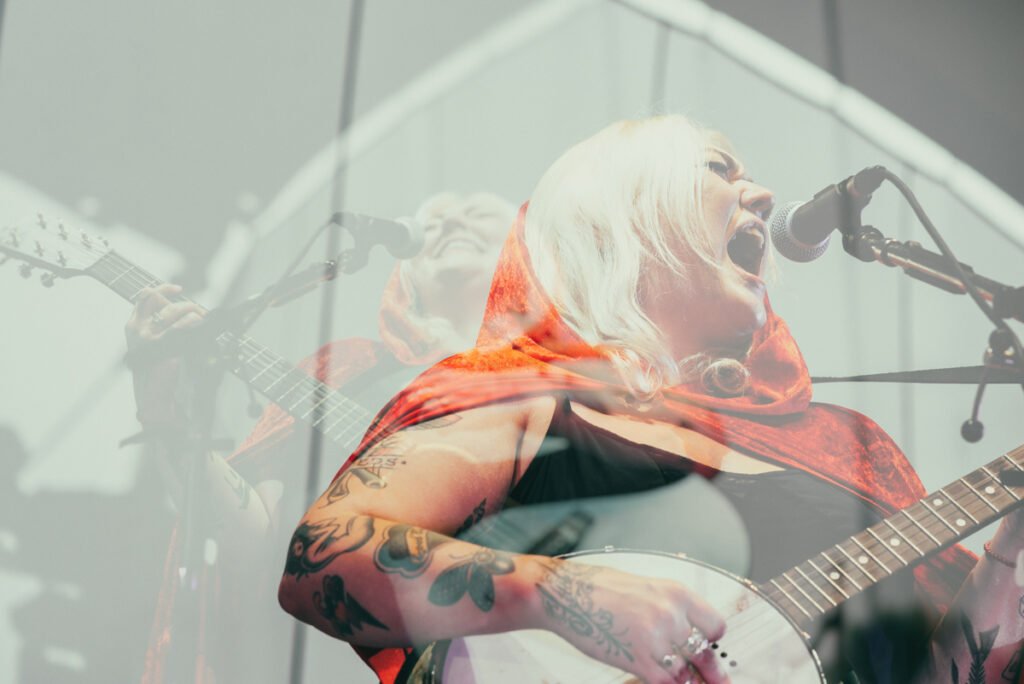 Elle King performing on stage with a banjo